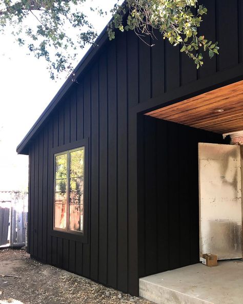 No photo description available. Black Metal Board And Batten Siding, Brown Board And Batten Siding, Black Exterior House With Wood Accents, Black Cedar House, Black Siding Exterior, 70s Ranch Exterior Remodel, Modular Exterior, Vertical Siding Exterior, Black Facade