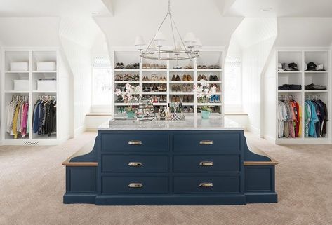 This spacious walk-in closet boasts an eye-catching navy blue island fitted with built-in benches with stained wood seats and accented with chrome cup pulls and a gray marble countertop illuminated by a ring chandelier. Dresser With Marble Top, Built In Benches, Grey Bunk Beds, Blue Closet, Transitional Closet, Mirrored Wardrobe Doors, Blue Kitchen Island, Contemporary Closet, Closet Island