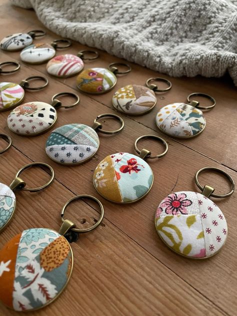 Gathered up some of my favorite bits of fabric to create these pretty key rings.  Each is made to be like a mini quilt, there are 20 included in this.  First I stitch up tiny little crazy quilts that are them made into buttons.  Next they are inlaid on a metal bezel and suspended from a keyring. Each bezel measures 1.5 inches and comes suspended from a 1 inch split ring. This listing is a bulk grouping of my quilt keychains.  I created this for when you need a little token of appreciation for la Quilted Jewelry, Small Quilted Gifts, Sew Gifts, Fabric Keychain, Quilt Retreat, Quilted Gifts, Keychain Fob, Group Gifts, Handmade Ideas