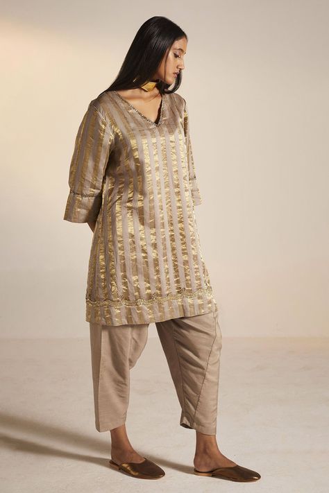 Taupe grey kurta with stripe print and embroidered neckline. Paired with salwar. Component: 2 Pattern: Printed Type Of Work: Stripe Neckline: V neck Sleeve Type: Three quarter Fabric: Handloom Tissue, Cotton Silk Color: Grey Other Details:  Approximate Product Weight (in kg): 1 Embroidered neckline Note: Dupatta worn by the model is not for sale Since all our products are sustainable and touched by human hands for weaving, block printing and embroidery; there might be a slight imperfections that Simple Indian Suits, V Neck Kurta, Salwar Kurta, Kurta Set For Women, Simple Kurta Designs, Embroidered Neckline, Indian Designer Outfits, Kurta Designs, Kurta Set