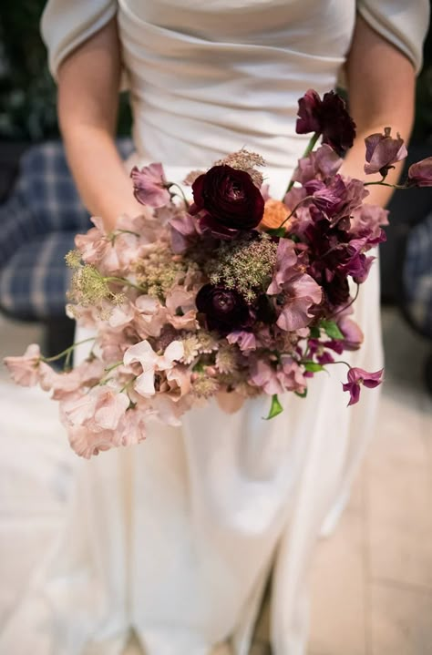 REAL WEDDING: Cassie + Ryan, The Alcove, OTR, Cincinnati – Eve Floral Co. A modern and romantic New Year's Eve wedding in Cincinnati, Ohio. Wedding planner: Block Party Event Co. Florist: Eve Floral Co. Photographer: Bri Nicole Location: Alcove by Madtree Sweet pea bridal bouquet with black velvet ribbon Plum Winter Wedding, Bridal Bouquet Moody, Mauve And Black Wedding, January Bouquet, Bridal Bouquet With Black, Sweet Pea Bridal Bouquet, Sweet Pea Wedding Bouquet, Hellebore Bouquet, Asymmetrical Bouquet