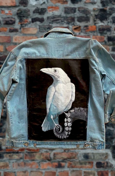 Woman's oversized Hand painted denim jacket. Customizable to order. Add a name or expression above the painting near collar. This Surrealism painting of a white crow standing on octopus arm is straight out of my gothic mind. This is  the first of a series of paintings done on denim jackets called Animal. Animal describes the many states of my mental and emotional health. The difficulties I go through as an artist, suffering with the darkness. Each animal represents a struggle.  It's not titled. I would love to know what do you think of it? Jeans Jacket Painting, Jean Jacket Painted Ideas, Customized Denim Jacket, Back Of Denim Jacket, Jean Jacket Painted, Jean Painting, Hand Painted Clothes, Hand Painted Jean Jacket, Roblox Drawing