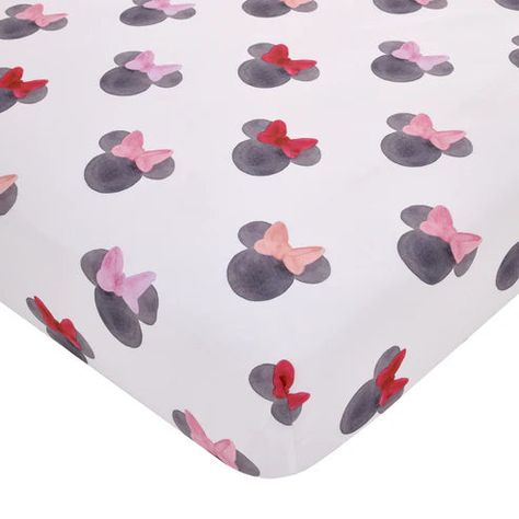 Add some playful whimsy to your nursery with this cute Disney Minnie Mouse Fitted Crib Sheet. Featured in a watercolor style with Minnie's iconic ears and bright bows in shades of black, red, pink, peach and white. Includes full elastic edges for a safe and snug fit. Made of cozy soft fabrics and measures 28" x 52" x 8". Fits a standard size crib/toddler mattress. Machine washable for easy care. The perfect touch for any Disney nursery!  This adorable Disney Minnie Mouse Fitted Crib Sheet features Minnie's iconic ears with brightly colored bows!  Designed in a watercolor style in shades of black, red, pink, peach and white  Includes full elastic edges for a safe and snug fit!  This sheet measures 28in x 52in x 8in and fits a standard size crib/toddler mattress  Made of cozy soft fabrics  M Minnie Mouse Bedroom Decor, Hello Kitty Nursery, Minnie Mouse Nursery, Mickey Mouse Nursery, Minnie Mouse Bedroom, Mouse Watercolor, Disney Nursery, Baby Crib Sheets, Mini Crib Sheets