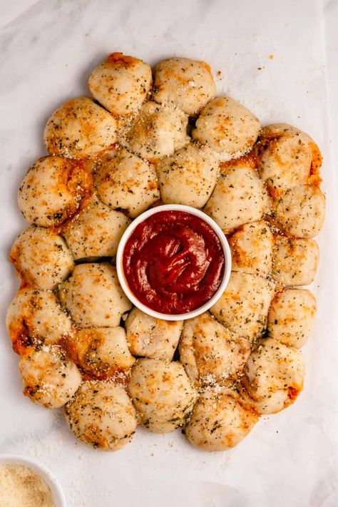 Pizza poppers, or pull apart pizza bites, are a fun and kid-friendly finger food for your next party!. Pizza sauce and mozzarella cheese are stuffed in pizza dough balls and baked in an irresistible herb and butter sauce. Pizza Poppers can be customized to include your favorite pizza toppings. Ready in less than 20 minutes! Four Dips With Pizza Dough Balls, Pizza Dough Mozzarella Balls, Pizza Balls With Pizza Dough, Pull Apart Pizza Bites, Pizza Bites Appetizer, Pizza Dough Balls, Pizza Poppers, Food For Parties, Super Bowl Snack Recipes