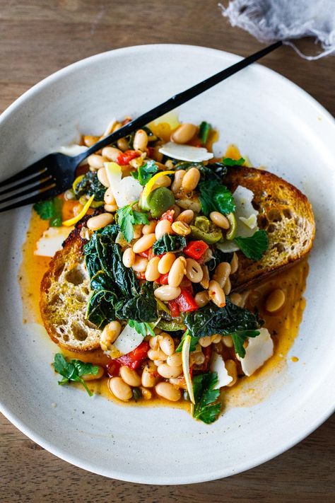 Brothy Beans over garlic-infused sourdough toast w/ lacinato kale, roasted peppers, olives, capers & lemon zest - an easy 30 minute meal! Brothy Beans, Beans And Greens, Lacinato Kale, Feasting At Home, Garlic Toast, Crispy Garlic, 30 Minute Meals Easy, Beans On Toast, High Protein Vegetarian Recipes