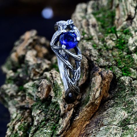 This sterling silver ring boasts a woodland-themed design, featuring enchanting vines inspired by elvish craftsmanship. The deep blue sapphire stone adds a touch of regality, making it a symbol of love and commitment. This male promise ring, infused with fairycore aesthetics, captures the essence of fantasy jewelry for him.  Characteristics: Metal - Recycled solid sterling silver  Stone - Cubic Zirconia Finish - Oxidized. View all silver mens nature wedding rings: https://www.etsy.com/shop/TinyShinyJewel?ref=seller-platform-mcnav&section_id=45544217 Care instructions: To care for the ring, avoid contact with water and chemicals such as perfumes and lotions. When the ring is not in use, store it in a dry, cool place to prevent tarnishing. Additional information:  ✦ All rings are made to ord Fantasy Male Wedding Ring, Male Engagement Ring Men, Fantasy Rings Magic, Goth Engagement Rings, Male Engagement Ring, Nature Rings, Elven Ring, Nature Wedding Ring, Jewelry For Him