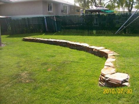 This low retaining wall adds more interest to this yard with a slightly  sloped backyard. Adding garden beds in and around the wall will soften it up with colour. Picture compliments of Dream-yard. Low Retaining Wall, Landscaping Walls, Yard Stones, Backyard Retaining Walls, Budget Landscaping, Large Backyard Landscaping, Sloped Yard, Backyard Garden Layout, Sloped Backyard