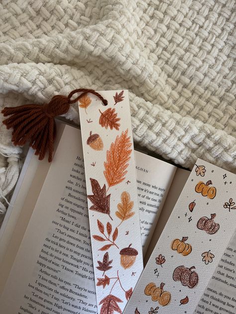 Cute fall themed bookmarks with pumpkin and fall foliage designs in colored pencils on card stock with yarn pompoms Fall Bookmarks Aesthetic, Color Pencil Bookmarks, Pumpkin Craft Idea, Aesthetic Handmade Bookmarks, Fall Themed Bookmarks, Fall Themed Crafts For Adults, Diy Fall Bookmarks, Fall Bookmark Ideas, Fall Bookmarks Diy