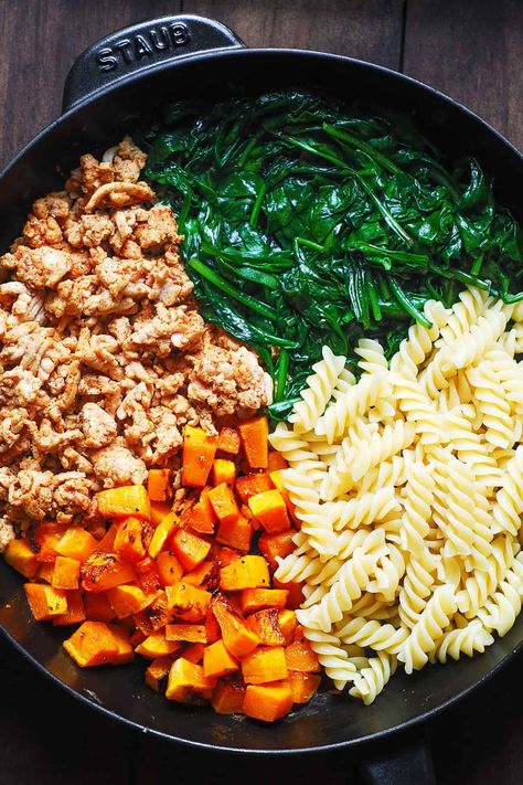 Ingredients for pasta in a cast-iron skillet: cooked ground turkey, cooked spinach, cooked pasta, roasted butternut squash Butternut Squash And Spinach Pasta, Ground Chicken And Butternut Squash, Ground Turkey Protein Pasta, Butternut Squash With Ground Turkey, Butternut Squash And Turkey Recipes, Turkey And Squash Recipes, Turkey Squash Skillet, Butternut Squash Turkey Recipes, Healthy Ground Turkey Pasta Recipes