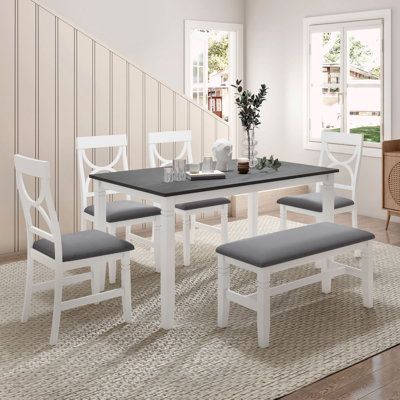 Look at this cute dining set! 6 pieces with 4 padded chairs and 1 bench that will seat up to 5 people at least. All of them are made of solid wood and the 60x36-inch large top will be enough surface to hold your dining dishes and the extra vases. Engraved legs and circle backs will completely get compliments from every visitor because of their elegance and grace. Table Base Color: White, Chair Color: White/Gray, Bench Color: White/Gray | Red Barrel Studio® 6 - Person Table Dining Set Wood / Upho Wood Dining Table Set, Kitchen Table Set, Set Meja Makan, Kitchen Table Wood, Dining Furniture Sets, Dining Room Table Set, 4 Dining Chairs, White Dining Chairs, Kitchen Dining Sets