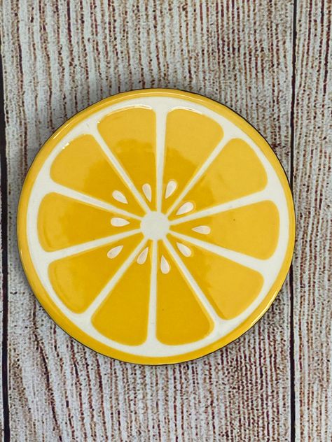 Lovely lemon coasters that brighten your table while keeping it safe!  This listing is for a set of 4 hand painted ceramic coasters.  Each coaster measures 4.25 wide x .25 high.  Coasters are hand painted with glaze then fired to perfection.  No vinyl or decals here!  Each set is made to order and will take an average of 7-10 days to create before it is shipped.  Since all pieces are individually handmade, please know that slight variations are to be expected. Fruit Coasters Paint, Citrus Coasters Ceramic, Lemon Ceramic Painting, Lemon Plate Pottery, Diy Coaster Designs Ideas, Costers Diy Paint, Diy Painted Ceramics, Cute Clay Coasters, Ceramic Coaster Painting Ideas