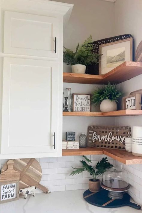 For added storage or to showcase your decorative items, consider adorning your kitchen corners with floating shelves. These space-saving shelves harmoniously align with your kitchen cabinets and create an alluring backdrop over the backsplash. The color and material of the shelves can further enhance your existing decor. Kitchen Corner Shelf Decor, Kitchen Corner Decor Ideas, Corner Shelves Kitchen Cabinet, Corner Kitchen Shelves, Decorate Kitchen Shelves, How To Decorate Kitchen Shelves, Corner Shelves Kitchen, Kitchen Corner Ideas, Corner Shelf Decor