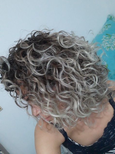 Silver is beautiful, no matter if those cliche glossy hair dye ads try to tell us the opposite. Icy Blonde Highlights Curly Hair, White Highlights Curly Hair, Hair Grey Highlights, Permanent Waves Hair, Curly Light Brown Hair, Short Layered Curly Hair, Blonde Highlights Curly Hair, Gray Roots, Short Curly Bob Hairstyles