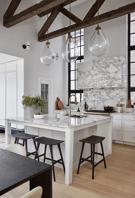 By having a square kitchen island with a white and marble finish, the designers of this kitchen were able to include four spaces for seating in the form of counter stools, which is ideal if you're entertaining and want to interact with the person cooking, or if you need a spot to have a quick bite to eat. #SquareIsland #SquareKitchenIsland #KitchenDesign #KitchenIsland #IslandWithSeating Square Kitchen Island, Square Island, Square Kitchen, Kitchen Seating, Casual Seating, Kitchen Island With Seating, Stone Kitchen, Kitchen Design Plans, Island With Seating