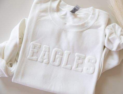 Custom Team Name Sweatshirt, Mascot Sweatshirt, Puff Print, Embossed Print, Gift for Mom, Christmas Gift Idea, School Spirit Sweatshirt The font shown in the main listing image is the font that will be used if you purchase this listing. YOUTH Available via the link below: https://www.etsy.com/listing/1762827919/youth-custom-team-name-sweatshirt-mascot T-SHIRT Available via the link below: https://www.etsy.com/listing/1763466061/custom-team-name-tshirt-mascot-t-shirt The main listing image (EAGLE Name Sweatshirt, Gift For Mom Christmas, School Sweatshirts, School Spirit Shirts, Embossed Printing, Puff Print, Spirit Shirts, Mom Christmas, Spirit Wear