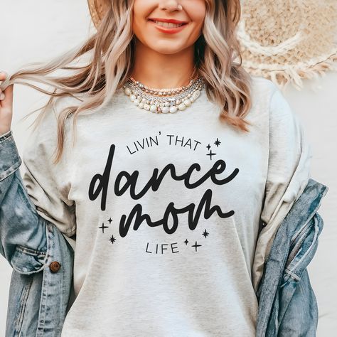 Dance mamas, we made the perfect shirt for watching your little dancer in class, dress rehearsal or a performance! Our dance mom life tee is available in pink and ash, and is soooo cute to match our dance your heart out tee for the littles! This design is also available in a match tote bag to carry around dance shoes, extra water, snacks and maybe a hairbrush for those ballet buns?? DETAILS Unisex sizing - aka mens sizing. If you want a looser fit, we recommend ordering your normal size or one up for an oversized fit. If you prefer a more fitted style, size down one. Tee - 52/48 Airlume combed and ringspun cotton/polyester. Side seams, shoulder to shoulder taping, tearaway label. Pink or Ash tee with black print Dancer Tshirt Ideas, Dance Family Shirts, Dance Tshirt Ideas, Dance Mom Shirts Design, Dance Studio Merch, Dance Mom Tshirt Ideas, Dance Mom Shirt Ideas, Ballet Buns, Dance Shirts Ideas