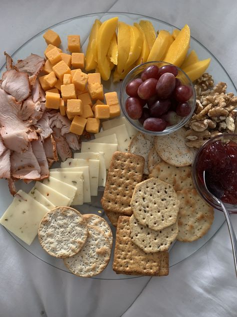 This plate contains sharp cheddar cheese cubes, pepper jack cheese slices, different flavor crackers, turkey ham slices, grapes, strawberry jelly, mango slices and walnuts. All set on a lazy Susan. Ham Slices, Mango Slices, Turkey Ham, Healthy Plate, Strawberry Jelly, Cheese Snacks, Cheese Cubes, Cracker Snacks, Delicious Snacks