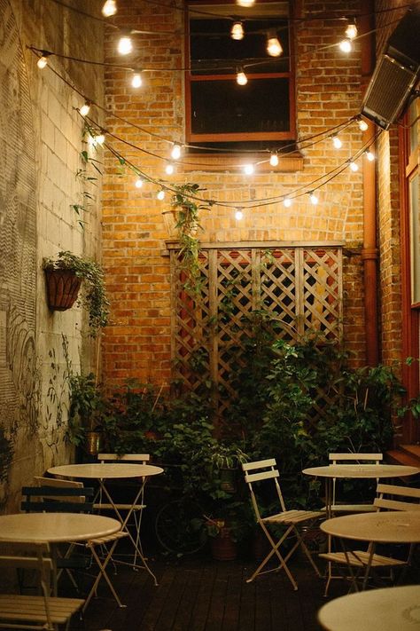 Create your own cozy cafe using string lights and a basic bistro set! Backyard Cafe, Outdoor Restaurant Patio, Rustic Cafe, Cafe Seating, Restaurant Patio, Patio String Lights, Bistro Lights, 카페 인테리어 디자인, Cafe Bistro