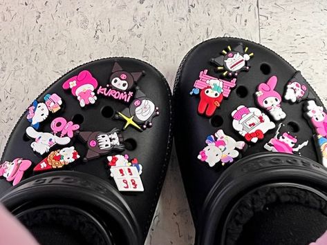 Hello Kitty Crocs Jibbitz, Hello Kitty Crocs Aesthetic, Black Crocs With Hello Kitty Charms, Hello Kitty Crocs Charms, Crocs With Hello Kitty Charms, Kuromi Crocs, Cute Black Crocs, Black Crocs With Charms, Black Crocs Aesthetic