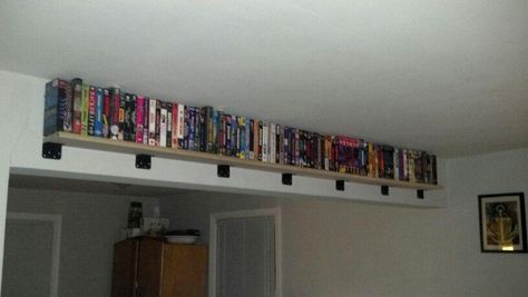 New shelf to display our VHS collection. A poplar 1x6 and 7 l-braces we spray painted black. Great use of that 'unusable' beam in the middle of our room! Vhs Display Ideas, Vhs Shelf, Peewee's Playhouse, Vhs Ideas, Vhs Display, Movie Shelf, Vhs Collection, How To Be Single Movie, Pizza Shop