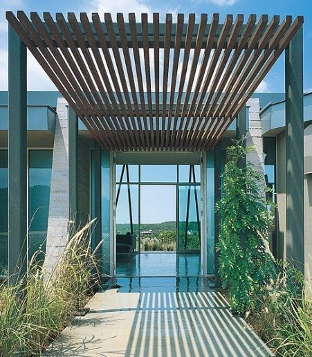 The entrance arbor made of a steel frame and a redwood canopy draws the eye through the living space to the nearly... Door Canopy Modern, Ranch Architecture, House Concept, Canopy Architecture, Gray Photography, Covered Walkway, Modern Entry, Hotel Entrance, Door Canopy