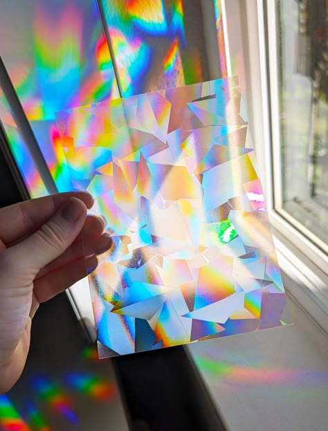 Our popular rainbow prismatic suncatcher film is now available in our new Confetti Pattern! Both "Glacier" and "Confetti" patterns create the same types of rainbows in your room; they just look a bit different on the windows! You can choose which one you'd like in the drop-down menu! :)  🌈☀️ Rainbow Suncatcher size: 4.5" x 6" (one sheet included per order) Use this gorgeous piece of rainbow suncatcher window film by itself, or get crafty and cut it up into your own shapes! When handling the sun Sun Catcher Window Film, Colorful Window Film, Rainbow Window Film Ideas, Rainbow Prism Window Film, Prism Mobile, Window Rainbow Film, Holographic Window Film, Prism Aesthetic, Prism Decor