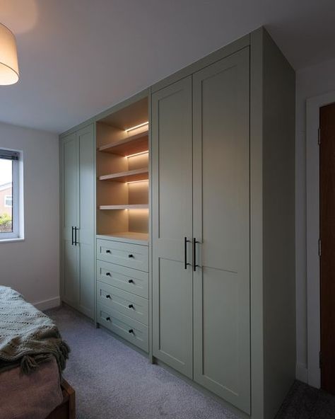 Lymm Fitted Furniture on Instagram: "Shaker fitted wardrobe….  Another fitted wardrobe installed On this wardrobe the customer opted for shaker style doors finished in f&b - vert de Open shelving with led lighting from @hafeleuk  Internals and shelves made from @finsauk roble natural mesura Handles from @plankhardware  Soft close hinges and drawers using only the best @blum_uk from @ldl_online   All our fitted furniture is made and sprayed in our workshop in Lymm, Cheshire  #fittedfurniture #fittedwardrobes #wardrobe #wardrobeinteriors #bedroomdecor #bedroominspo #bedroom #storage #storagesolutions #storageideas #closet #lymm #cheshire #thursday #instagram #instadaily #photography #photooftheday #ledlighting #hafele #vertdeterrefarrowandball" Built In Wall Wardrobe Ideas, Built In Wardrobe Ideas With Drawers, Fitted Wardrobe With Tv Built Ins, Wardrobe Area In Bedroom, Wall Length Wardrobe, Cozy Bedroom Wardrobe, Hinged Door Wardrobe, Fitted Wardrobes With Drawers, Bedroom Fitted Furniture