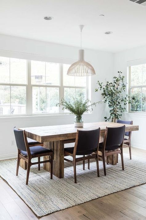 A reclaimed wood chunky dining table sits on a white rug surrounded by leather and wood dining chairs lit by a white pendant. Chunky Dining Table, Brown Wood Dining Table, Latest Dining Table, Wood Slab Dining Table, Large Round Dining Table, Cottage Dining Rooms, Grey Dining Tables, Transitional Dining Room, Pure Salt