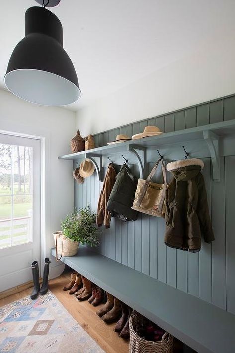 A blue mudroom bench is fixed against blue shiplap trim under oil rubbed bronze hooks fixed beneath a blue shelf. Country Boot Room, Lakehouse Mudroom, Mudroom Walls, Blue Mudroom, Blue Shiplap, Shiplap Trim, Cloakroom Ideas, Cottage Laundry Room, Cloak Room