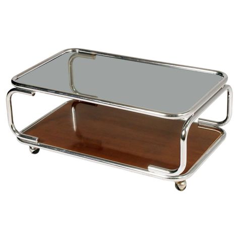 This mid-century coffee table was produced in Italy in the 1960s. It features a chromed metal base on casters and a smoked glass top on faux laminated wood. Adjustable Height Coffee Table, Geometric Coffee Table, Modern Wood Coffee Table, Wood For Sale, Serving Trolley, Coffee Table Trunk, Mid Century Modern Coffee Table, Mid Century Coffee Table, Oval Coffee Tables