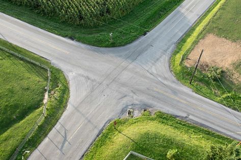 An aerial view of a road intersection with fields on the sides. Road Intersection, Aerial Images, React Native, A Love So Beautiful, Mobile Applications, Race Track, Aerial View, Golf Courses, Country Roads