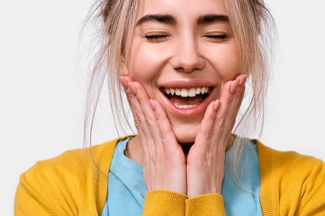 Close up portrait of surprised young woman smiling holds cheeks by hands. Happy female hears something pleasant, keeps hands on cheeks and closing eyes, isolated over white background. People emotions Hands On Cheeks, People Emotions, People Images, Close Up Portrait, Woman Smiling, Menstrual Health, Health And Fitness Magazine, Wax Strips, Home Health Remedies