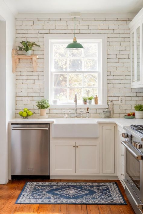 A small kitchen with white cabinetry, a farmhouse sink, and a white brick backsplash, complemented by a green pendant light and a blue rug Exposed Brick Kitchen Backsplash, Brick Kitchen Backsplash Ideas, White Exposed Brick, White Brick Kitchen, White Brick Backsplash, Exposed Brick Kitchen, Backsplash Kitchen Ideas, Brick Kitchen Backsplash, Green Pendant Light