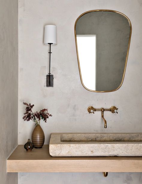 Limewash paint from Portola Paint & Glazes adds an aged quality to the powder room walls. The more traditional fixtures and furnishings, such as the unlacquered brass Waterworks faucet, the vintage limestone sink from Ancient Surfaces in New York, O’Lampia sconce and a vintage Italian mirror from 1stdibs break from the rest of the home’s modern silhouettes. Katie Hodges Design, Limestone Sink, Portola Paint, French Limestone, Luxe Interiors, Residential Interior Design, California Homes, Residential Interior, Organic Modern