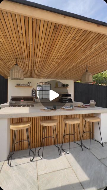 Esme | Garden Design & Landscaping on Instagram: "ALL WEATHER OUTDOOR KITCHEN 👨🏻‍🍳🍔🍕Our classic concrete x render kitchen but this time, it’s rain-ready!🌧️ Which means, outdoor BBQ’s & entertaining all year round (sub degree temperatures excluded)

We fitted out this incredible galley way kitchen for the Brookfield family with:
→ Two concrete counters; worktop & breakfast bar
→ @beefeaterbbq 7000 series 5 burner
→ @gozney pizza oven
→ @keburgarden larch wood pergola & cupboards
→ Ample storage space 
→ Integrated Bull fridge 
→ @sgweberuk chalk render walls

Drop us a message so we can build you your dream outdoor kitchen & entertainment space ✉️

#outdoorkitchen #outdoorliving #outdoorkitchendesign #gardendesign #landscaping" Outdoor Bar With Pizza Oven, Outdoor Fireplace And Kitchen Ideas, Outdoor Kitchen Design Wood, Outside Kitchen Ideas Outdoor Spaces, Bbq Area Ideas Outdoor, Gozney Pizza Oven, Garden Kitchen Outdoor, Deck Kitchen, Concrete Counters