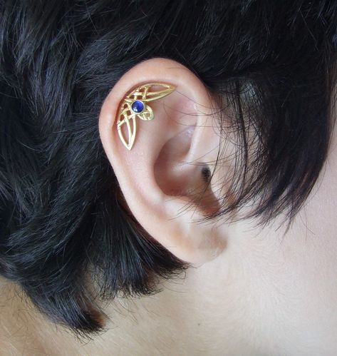 "This is a single helix piercing with intertwining Celtic designs. It comes as a single ear piercing, and fits both ears. It is made of 14k gold and stamped 14k on the backside. You can choose yellow, rose, or white 14k gold plating when you order. I plate the white gold with rhodium plating, as common in white gold jewelry. You can also choose the finish you want for the earring - matte ( as seen in pictures ) or shiny. In the pictures, you can see the earring with a blue topaz stone, which is Pretty Helix Earrings, Helix Jewelry Cartilage Piercings, Curved Helix Earring, Single Helix Piercing, Piercing Inspo Ear, Hidden Helix Piercing, Single Ear Piercing, Cartilage Piercing Ideas, Gold Helix Earrings