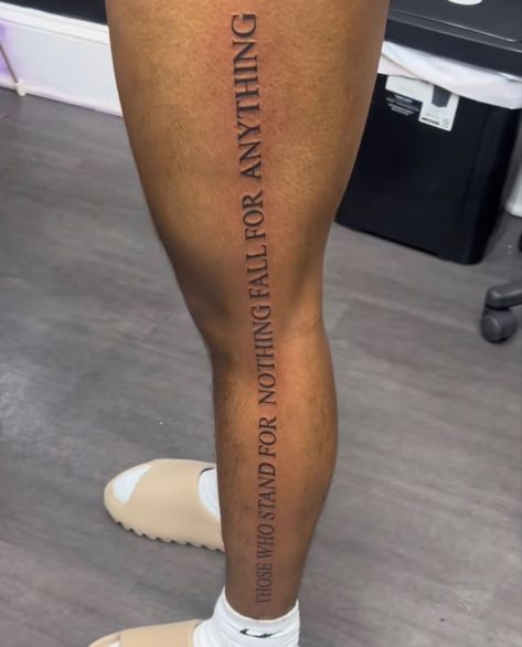 Back Of Wrist Tattoo Men, A Man Who Stands For Nothing Tattoo, Word Leg Tattoos Men, Authentic Tattoo Ideas, Quote Down Leg Tattoo, Tattoo Ideas For Men Meaningful Leg, Leg Tattoo Men Simple, Side Of Leg Tattoo Men, Trendy Tattoos 2024