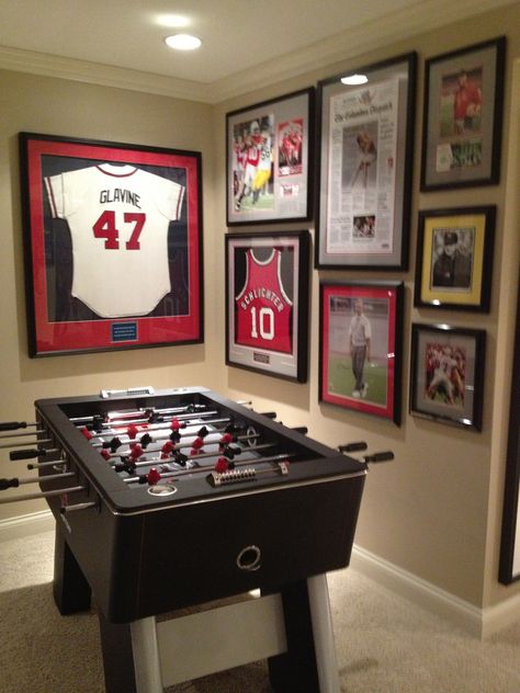 Great memorabilia wall Sports Memorabilia Display Wall Man Cave, Jersey Wall Display Man Cave, Memorabilia Wall Ideas, Sports Memorabilia Office, Sport Memorabilia Display Wall, Memorbillia Display Ideas, Sports Memorabilia Display Ideas, Framed Jerseys On Wall, Sports Memorabilia Display Wall