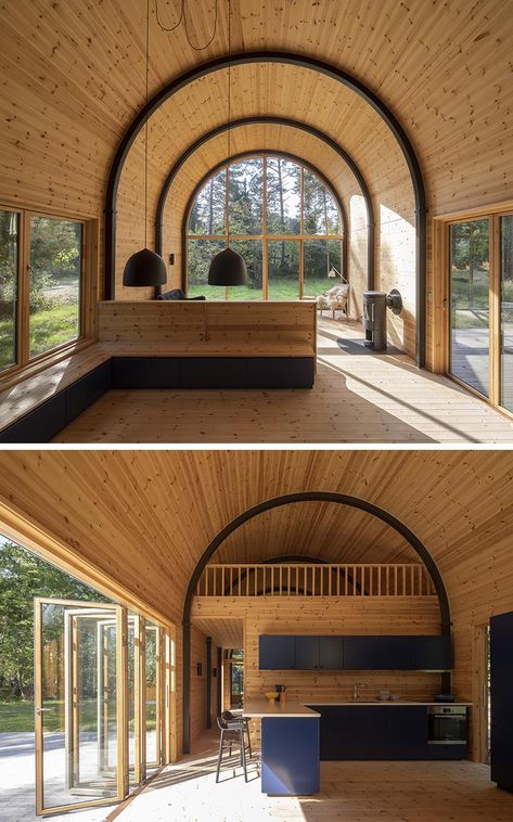 Inside this modern house with a curved vaulted ceiling, there's 8 eye-catching arched steel beams that provide the support for the structure, and at the same time, they create a strong contrast to the minimalist pine wood interior. #CurvedCeiling #VaultedCeiling #PineInterior #WoodInterior #ArchedBeams #SteelBeams #ModernHouse Micro Resort, Architecture Ceiling, Quonset Homes, Quonset Hut Homes, Arched Cabin, Arch Building, Corrugated Metal Roof, Quonset Hut, Arch House