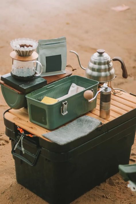 The best camping kitchens are compact and portable like the one pictured here: a dark green plastic tub with a wooden-slat top, and coffee-making supplies laid out on it. Aesthetic Camping Set Up, Outdoor Cooking Camping, Camping Kitchen Storage, Aesthetic Camping Gear, Camp Barbie, Japanese Camping, Camping Kitchen Set Up, Camping Setup Ideas, Camping Storage Ideas