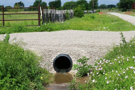 If you are observant enough, when you walk on a bridge, you may notice a small rectangular or square structure beneath the bridge as you pass through. That structure is called a culvert and is an essential component responsible for ensuring the smooth flow of water under roads and trails. You may not be aware of this, but there are distinct types of culverts, each with its purpose. This article will discuss everything you need to know about culverts, whether you're in construction or just ... Diy Culvert Ideas, Driveway Culvert Ideas, Culvert Landscaping Ideas Drainage Ditch, Culvert Landscaping Ideas, Culverts Ideas, Driveway Culvert, Water Erosion, Backyard Landscapes, Drainage Ditch