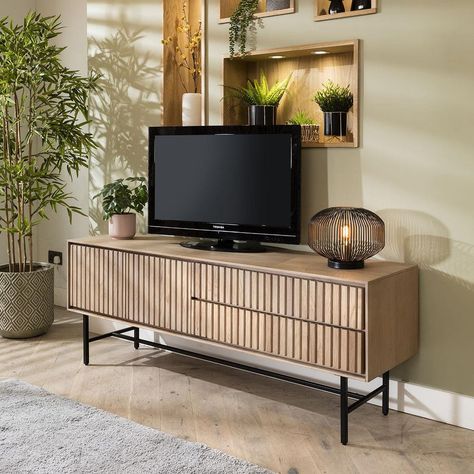 A modern TV stand crafted for both style and functionality. The cabinet, crafted from solid wood with a natural oak veneer, has a grooved finish to enhance acoustic performance for an immersive viewing experience. A chamfered edge on the back allows it be to wall-hung, transforming it into a floating television stand. With a spacious double door cupboard, organising your entertainment essentials becomes effortless. The stand's thoughtful layout includes an AV shelf behind a flip-down door, complete with a cable management hole, ensuring a clutter-free setup. Below, a convenient drawer provides additional storage while maintaining the unit's streamlined appearance, all accented by a handless design with push-open catches for seamless functionality. Elevating your viewing experience, the sta Corner Dining Bench, Corner Bench Dining Set, Wooden Tv Stand, Television Stand, Chamfered Edge, Corner Dining Set, Tv Stand Cabinet, Sideboards Living Room, Wooden Tv Stands