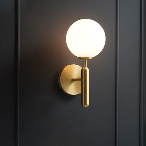 Stylish yet functional, this mid-century modern sconce wall sconce showcases an eye-catching glass shade. Featuring a white glass globe shade, perfect for showing off gold accents, this piece is excellent in any contemporary setting. It' s the perfect pick for your powder room. A compatible 7W bulb is included.   - Materials: Brass, Glass - Dimensions: 5.9"L x 7.1"D x 18.9"H (150mmL x 180mmD x 480mmH) - Bulbs: 7W LED G9 warm white lamp (included, not eligible for free replacement) - Assembly Ins Mid Century Modern Sconces, Globe Wall Light, Indoor Wall Sconces, Luminaire Mural, Modern Wall Sconces, Modern Sconces, Gold Walls, Leaded Glass, Wall Light Fixtures