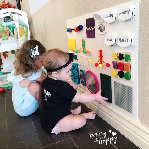 Dollar Store Busy Board – Noticing the Happy Infant Busy Board Diy, Wall Mounted Busy Board, Busy Board For 1 Year, Homemade Busy Board, Montessori Busy Board Diy, Infant Room Daycare, Diy Busy Board, Busy Board Baby, Sensory Wall