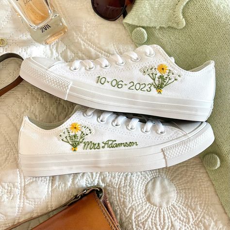 Fresh all white monochrome low top All Star Converse delicately hand embroidered with an intricate bouquet. The posy is made up of sunflowers, gypsophelia and eucalyptus, all tied together with a dainty bow and finished with a name, date, initials or words of your choice. This design can be embroidered in any colour scheme you choose. Each pair is hand made to order and stitched with high quality embroidery thread which is washable and fade resistant.  Optional extras include: Heel embroidery - Trainer Wedding Shoes, Embroidery Converse Wedding, Wedding Shoe Embroidery, Wedding All Stars Converse, Embroidery Wedding Shoes, Embroidered Bridal Shoes, Embroidered Converse Wedding, Embroidered Chucks, Bride Merch