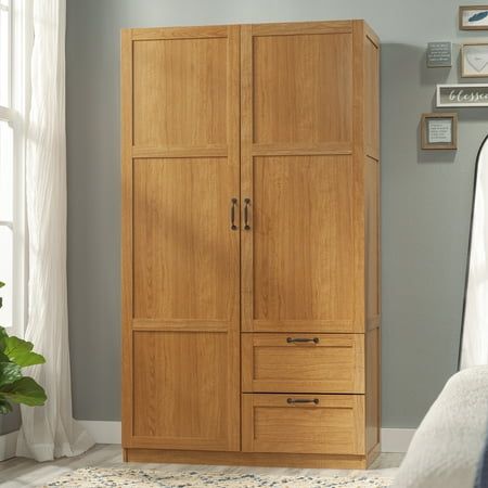 Need a place to store your abundance of stuff? Check out this practical and stylish storage cabinet from the Sauder Select collection. This clothing armoire features storage behind a full length door that includes a garment rod and fixed shelf for storing your jackets, sweaters, dress pants, and more. Additionally, this armoire with hanging rod includes one fixed and one adjustable shelf behind the right door so you can customize your storage space to fit your needs. This space is also perfect for organizing bins, bed or bathroom linens, or books. This wardrobe armoire also includes two deep storage drawers that glide on metal runners. The drawers in the wardrobe armoire are perfect for items like folded clothes, blankets, or pillows. Finished in a golden Highland Oak and detailed with fra Amoire Ideas Bedrooms, Sweater Storage Ideas, Office Armoire, Shelving Unit Bedroom, Clothing Armoire, Craft Armoire, Wardrobe Storage Cabinet, Wood Storage Cabinet, Folded Clothes