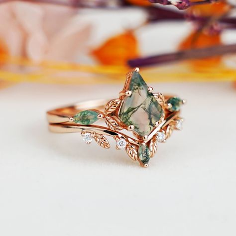 Elevate your special moments with the Leaf-Inspired Kite Cut Moss Agate Engagement Ring Set. Exquisitely handcrafted in 14k gold, this unique set features a natural moss agate gemstone, celebrated for its distinct green hues and organic patterns. The kite cut of the gemstone, nestled in a leaf-type design, adds an enchanting touch of nature-inspired elegance. Perfect as an engagement ring or a thoughtful gift for women, this ring set embodies both beauty and a deep connection to the natural worl Miss Agate And Diamond Ring, Miss Agate Kite Ring, Types Of Engagement Ring Stones, Kite Ring Set, Unique Gem Engagement Rings, Engagement Rings Without Stones, Moss Rings Engagement, Rose Gold Moss Agate Engagement Ring, Plant Inspired Engagement Rings