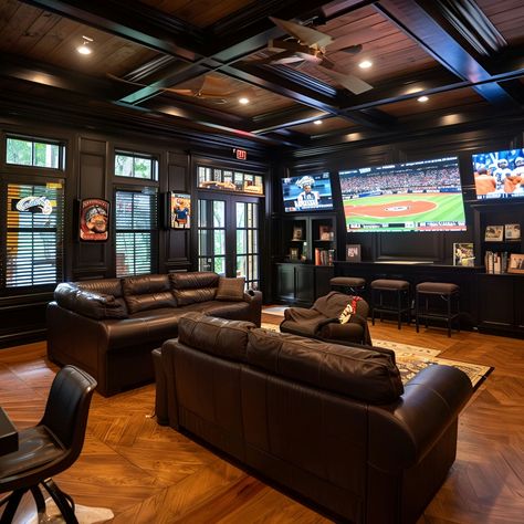 Ultimate man cave featuring luxurious black leather couches, dark wood paneling, and wood floors. Equipped with big screen TVs playing baseball, a bar with stools overlooking a scenic view, and cozy high ceilings. Perfect for sports fans with a minimalist, masculine design, this space includes an island bar for entertainment and built-in cabinets for storage. Man Cave Minimalistic, Man Cave Theater Room, Moody Sports Basement, Basement Whiskey Lounge, Dark Man Cave, Man Cave Tv Wall, Sports Man Cave Ideas, Apartment Man Cave, Modern Entertainment Room