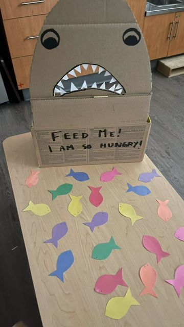 Brooke and Cat on Instagram: "Feed the Shark !🦈 . . . This week the toddler have had a great interest in water animals. So I thought this easy fun activity would be the right fit. All handmade. . . All you need is a cardboard box, some construction paper and your creativity. . . . Don’t forget to save and follow for more great ideas. . . . #popular #instagram #trending #follow #love #viral #like #instagood #explorepage #photography #explore #likeforlikes #followforfollowback #music #fashio Feed The Shark Activity, Aquatic Animals Preschool Activities, Sea Animals Activities For Toddlers, Baby Shark Activities For Toddlers, Shark In The Park Activities Eyfs, Shark Activities For Preschool, Sea Animals Preschool, Feed The Shark, Creative Activities For Toddlers