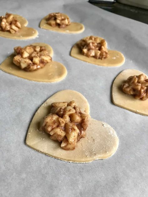 Apple Pie Hearts--Mini heart shaped pies stuffed with a cinnamon apple filling and topped with a sugary glaze! Perfect as a Valentine's Day dessert! (Or date night, or any night!) {cutsandcrumbles.com} #applepie #hearts #Valentinesday #Valentinesdessert #pie #easypie #easydessert #festivedessert #cutsandcrumbles Heart Apple Pie, Holiday Themed Desserts, Animal Shaped Foods, Valentines Treats, New Years Eve Food, Apple Hand Pies, Potluck Party, Mini Apple Pies, St Patricks Day Food